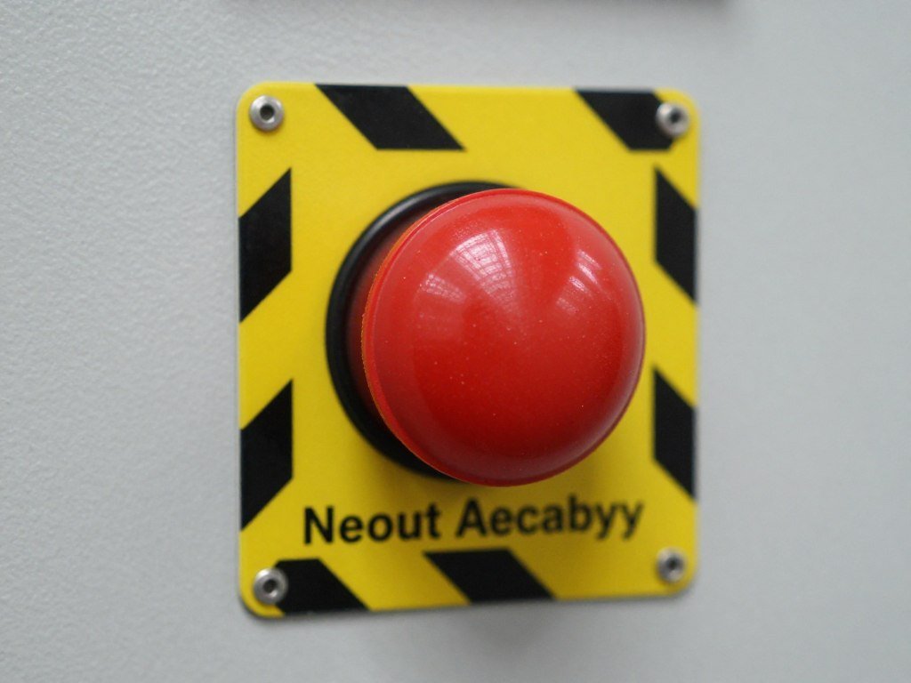 Close-up of red emergency stop button on brick making machine control panel